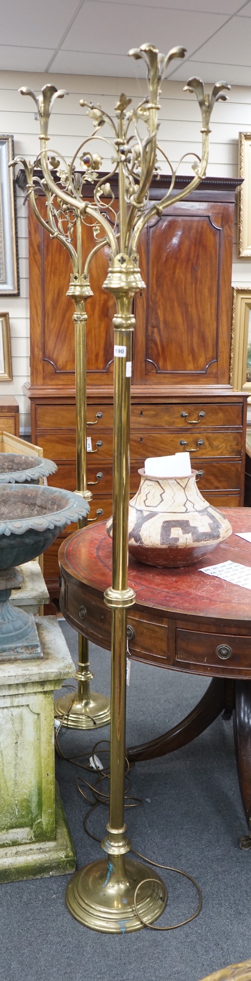A pair of Victorian Gothic brass ecclesiastical three branch floor lamps, converted to electricity, height 195cm